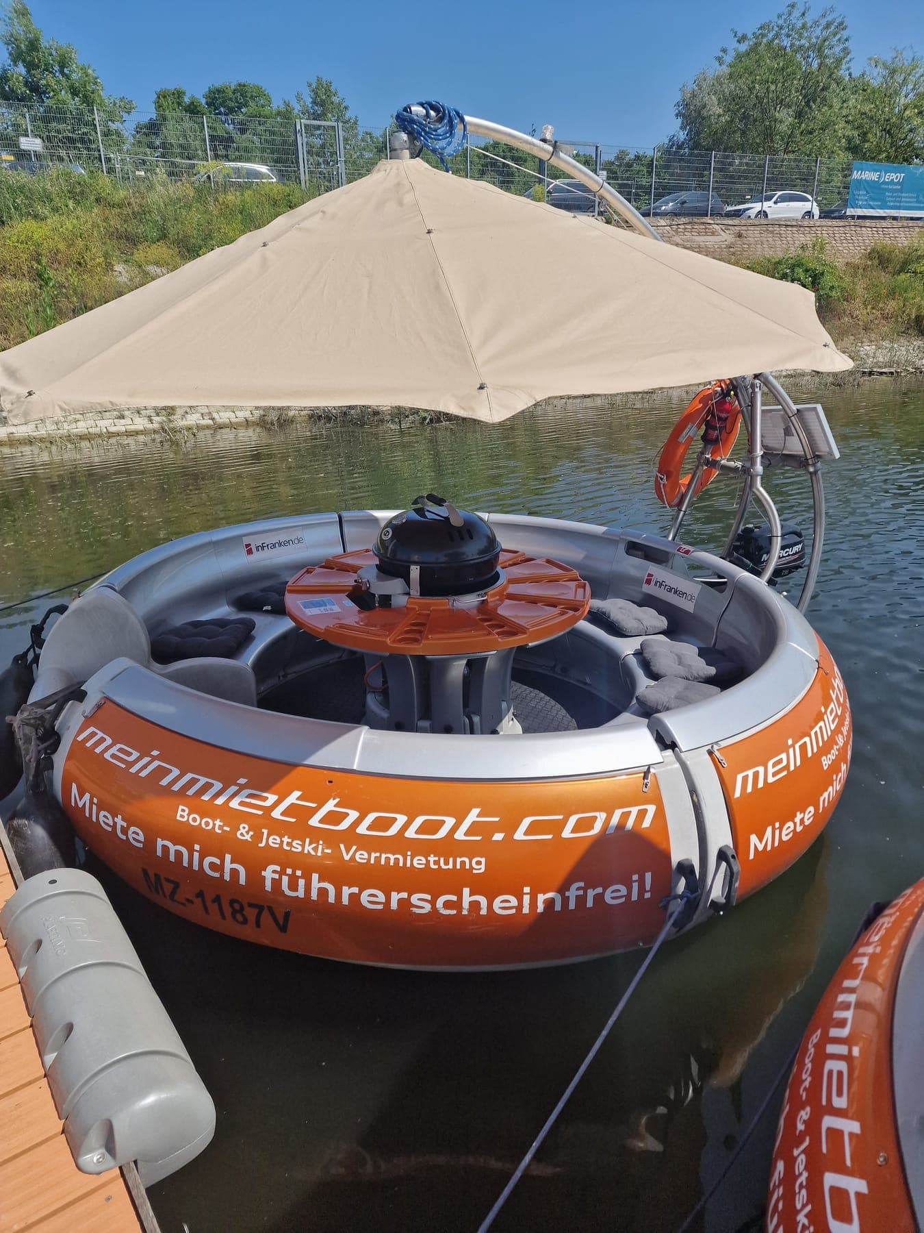 Runde Sitzbank mit Kissen und Grill im BBQ-Donut
